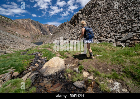 Young adult woman randonneur promenades le long du chemin de terre à travers les montagnes de l'Est de la Sierra en Californie, 20 Sentier du Bassin des Lacs Banque D'Images