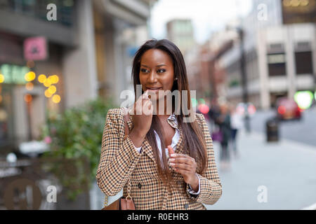 Young business woman putting on Lip Gloss Banque D'Images