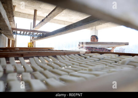 Qiandongnan, province du Guizhou en Chine. 4ème Nov, 2018. Un villageois se dessèche les gâteaux de riz gluant pour faire 'dongguo', le riz gluant frit avec du sucre brun et de sésame, dans Jiasuo Dong Village de Liping County, au sud-ouest de la province du Guizhou, Chine, 4 novembre 2018. 'Dongguo' est une sorte de snack pour les populations locales de Dong groupe ethnique à divertir les invités. Crédit : Yang Daifu/Xinhua/Alamy Live News Banque D'Images