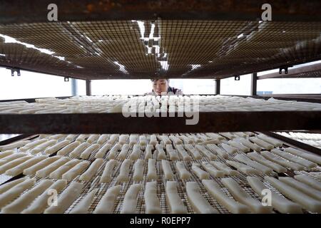 Qiandongnan, province du Guizhou en Chine. 4ème Nov, 2018. Un villageois de gâteaux de riz gluant en séchant au soleil pour faire 'dongguo', le riz gluant frit avec du sucre brun et de sésame, dans Jiasuo Dong Village de Liping County, au sud-ouest de la province du Guizhou, Chine, 4 novembre 2018. 'Dongguo' est une sorte de snack pour les populations locales de Dong groupe ethnique à divertir les invités. Crédit : Yang Daifu/Xinhua/Alamy Live News Banque D'Images