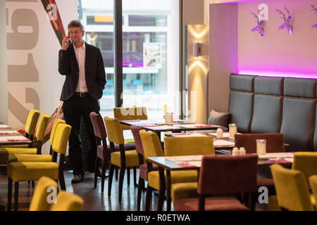 Munich, Bavière. 4ème Nov 2018. Michael Piazolo gratuitement (électeurs), membre du Parlement européen, la Bavière est téléphoner en un hôtel restaurant entre les tables et les chaises en marge de la coalition de la libre consultation des électeurs. CSU et gratuitement les électeurs veulent la coalition en Bavière, et sont d'approuver le contrat de coalition prévu. Photo : Lino Mirgeler/dpa dpa : Crédit photo alliance/Alamy Live News Banque D'Images