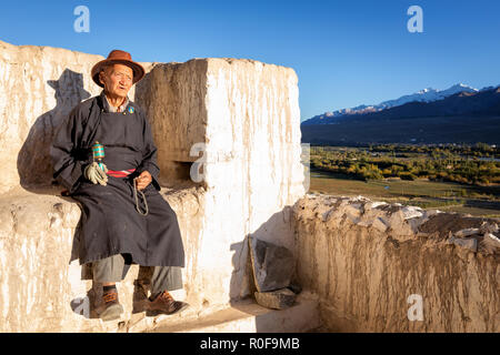 Un homme âgé avec un moulin à prières reposant à Gompa de Spituk, district de Leh, Ladakh, Inde Banque D'Images