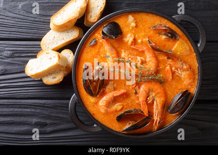 Fruits de mer soupe épicée avec pommes de terre, crevettes, moules, des herbes et des poissons d'un picad libre à la poêle servi avec du pain grillé. Haut horizontale Vue de dessus Banque D'Images