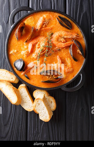 Fruits de mer soupe épicée avec pommes de terre, crevettes, moules, des herbes et des poissons d'un picad libre à la poêle servi avec du pain grillé. Haut Vertical Vue de dessus Banque D'Images
