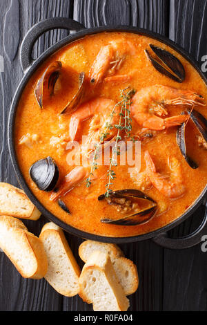 Authentique catalane Suquet de Peix soupe épicée avec pommes de terre, crevettes, moules, les herbes et le poisson avec picad close-up dans une casserole sur la table. Haut Vertical vi Banque D'Images