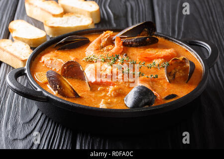 Fruits de mer soupe épicée avec pommes de terre, crevettes, moules, des herbes et des poissons d'un picad libre à la poêle servi avec du pain grillé. Banque D'Images