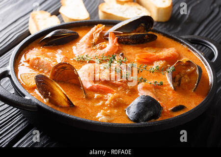 L'Espagnol Suquet de Peix soupe de la mer avec des pommes de terre, crevettes, moules, les herbes et le poisson avec picada dans une casserole sur la table horizontale. Banque D'Images
