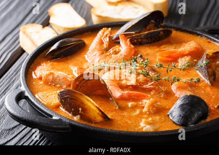 Le riche goût de fruits de mer Suquet de Peix soupe avec des pommes de terre, les herbes et les poissons avec l'ajout de picada close-up dans une casserole sur la table. horizonta Banque D'Images