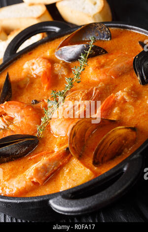 L'Espagnol Suquet de Peix soupe aux fruits de mer, pommes de terre, les herbes et le poisson close-up dans une casserole sur la table verticale. Banque D'Images
