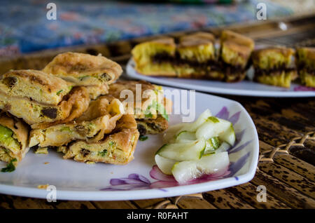 Le MARTABAK TELUR - crêpes farcies ou pan-fried bread Indo-style sur une assiette, close-up avec TERANG BULAN en arrière-plan Banque D'Images