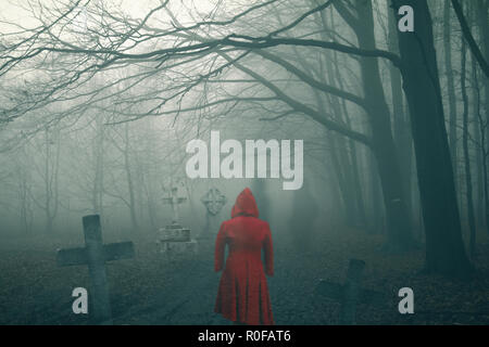 Ghost femme en robe rouge sombre sur le cimetière de la forêt de l'horreur Banque D'Images