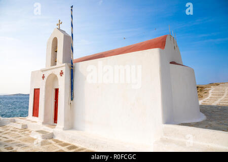 L'église grecque typique bâtiment blanc avec dôme rouge contre le ciel bleu sur l'île de Mykonos, Grèce Banque D'Images
