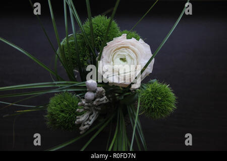Beau bouquet sombre avec green carnation moelleuses, une grande douceur et de l'herbe sur le Ranunculus Fond en bois noir, télévision lay Banque D'Images