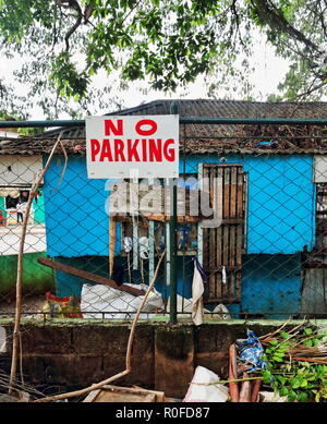 Aucun signal de stationnement agrafée sur une clôture sur un mur de brique d'arrière-cour couverte de détritus végétaux et des restes des articles en bois, un lieu où nobo Banque D'Images