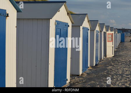 Peu de cabines de plage au coucher du soleil sur la mer du Nord sur waddeneiland Texel Hollande Europe. Banque D'Images