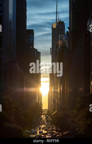 Coucher du soleil entre les immeubles de Manhattan avec crosstown trafic le long de la 42e Rue à New York City Banque D'Images