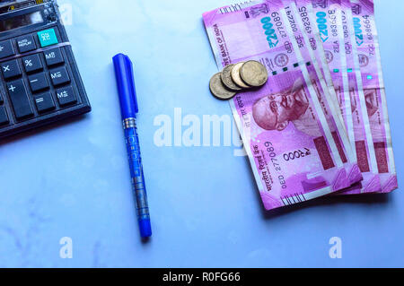 L'accent sur Gandhi. Papier-monnaie indienne de roupies et pièces en pile, calculatrice et stylo la croissance de l'entreprise symbole. Studio shot isolé sur fond blanc. Banque D'Images