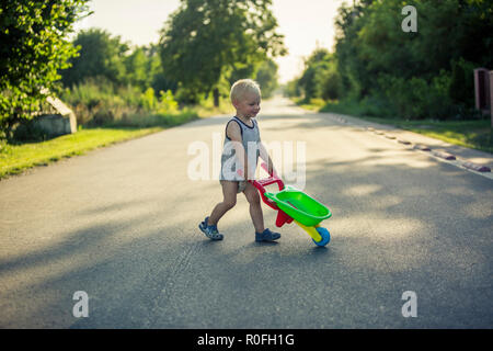 2 ans d'aider dans le jardin/verger Banque D'Images