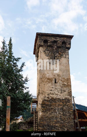 Old Stone svan tower sur rue de Mestia en ville, Svaneti la Géorgie. Ciel avec nuages de fond. Banque D'Images