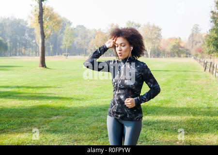 Activité saine, un centre de remise en forme parc African woman jogging à champs verts dans la nature Banque D'Images