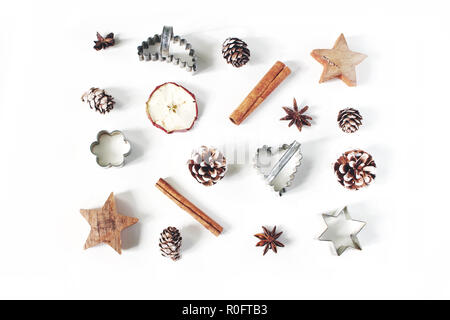 Fête de Noël, la composition des aliments de style tendance. Cônes de pin, pomme fruit séché, la cannelle, l'anis et d'un emporte-pièce vintage étoile isolated on white background. Mise à plat, vue du dessus. La cuisson au four. Banque D'Images