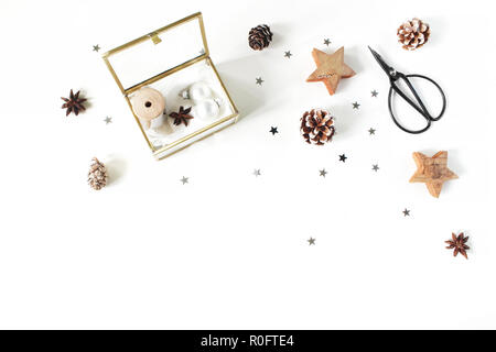 Composition d'artisanat de Noël. Rubans de soie et des boules de Noël en verre doré fort. Ciseaux vintage, pommes de pin, d'argent et de confettis étoiles en bois. Arrière-plan du tableau blanc. Mise à plat, vue du dessus Banque D'Images