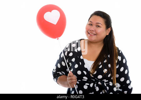 Studio shot of young woman smiling Asian fat heureux tout en maintenant Banque D'Images