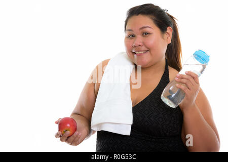 Studio shot of young woman smiling Asian fat heureux tout en maintenant Banque D'Images