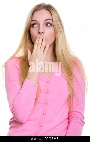 Studio shot of young Beautiful woman couvrant la bouche tout en Banque D'Images