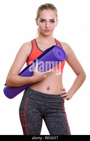 Studio shot of young Beautiful woman holding yoga mat et Banque D'Images