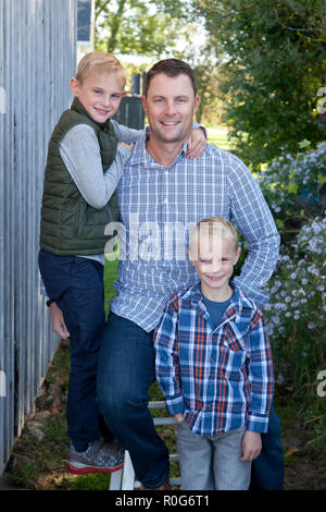 Beau blond avec un grand sourire et ses deux fils mignon à l'extérieur Banque D'Images