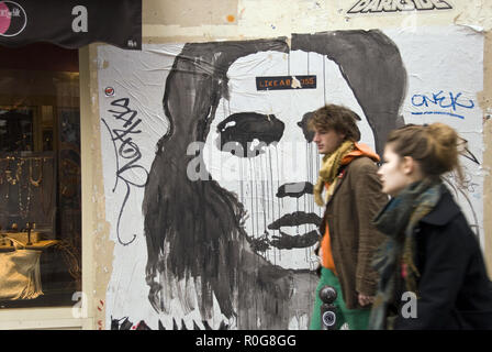 Les étudiants de l'université passer devant une affiche collée sur un mur dans le Quartier Latin, près de la Sorbonne, Paris, France. Banque D'Images