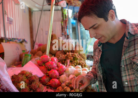 Beau touristiques persan man shopping for fruits dans street shop Banque D'Images