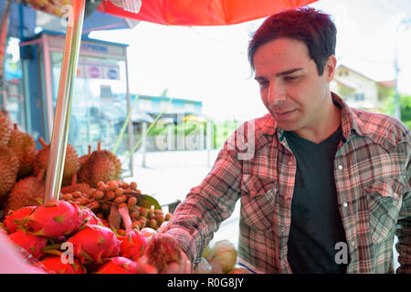 Beau touristiques persan man shopping for fruits dans street shop Banque D'Images