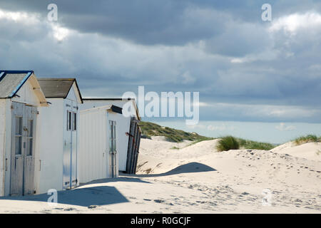 Peu de cabines de plage au coucher du soleil sur la mer du Nord sur waddeneiland Texel Hollande Europe. Banque D'Images