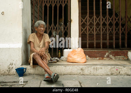 Street portrait d'une femme âgée assise dans l'embrasure, reportage style. La vie quotidienne des gens de la classe inférieure de Cartagena de Indias, Colombie. Sep 2018 Banque D'Images