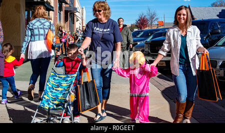 Emporia, Kansas, USA, Octobre 27, 2018 Les enfants vêtus de costumes de Halloween trick ou traiter le long de la rue commerciale Banque D'Images