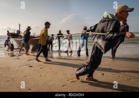 Bateau de pêcheurs tirant sur le rivage, Vung Tau, Vietnam. Banque D'Images