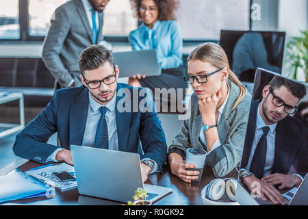 Multicultural businesspeople looking at portables dans l'espace Banque D'Images