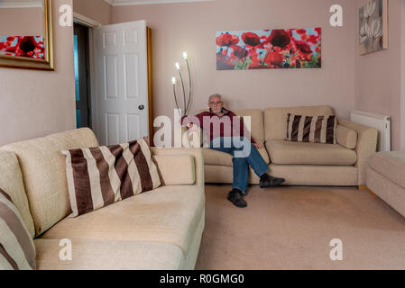 Seul Senior man sitting on sofa, le travail de deuil après avoir perdu un être cher. Triste solitude et tristesse. Banque D'Images