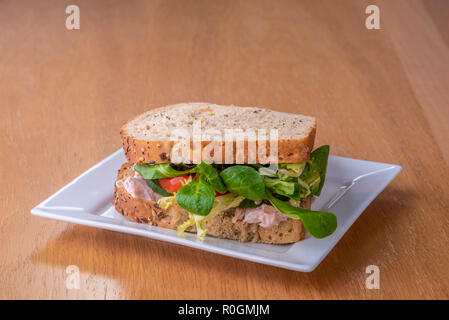 Sandwich à la salade de poulet sur une plaque blanche.Turquie laitue tomate pain grenier. Banque D'Images