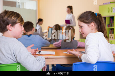 Portrait des enfants discuter quelque chose pendant la leçon à l'école Banque D'Images