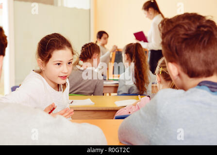 Portrait des enfants discuter quelque chose pendant la leçon à l'école Banque D'Images