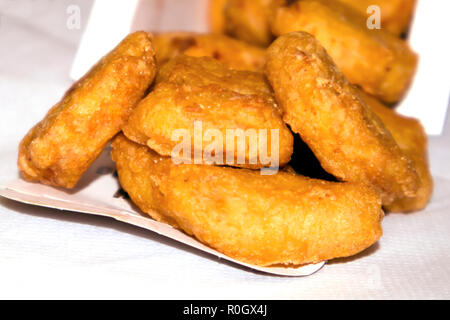 Pile de nuggets de poulet frit croustillant de tomber d'une boîte de papier Banque D'Images