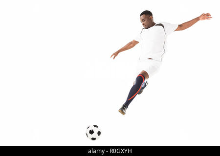 Young african american soccer player kicking ball dans jump isolated on white Banque D'Images