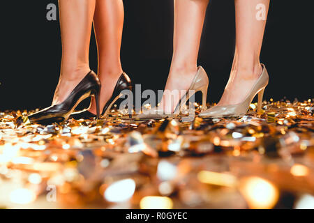 Portrait de in High heels standing on golden confetti sur partie Banque D'Images