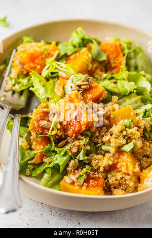 Salade de quinoa chaud et de citrouille dans une assiette blanche. La nourriture végétalienne Saine alimentation nourriture, concept. Banque D'Images