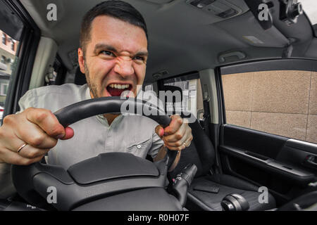 Personne émotionnelle. Le conducteur de la voiture crie à quelqu'un dans l'embouteillage. Concept hystériques et casse de voiture Banque D'Images