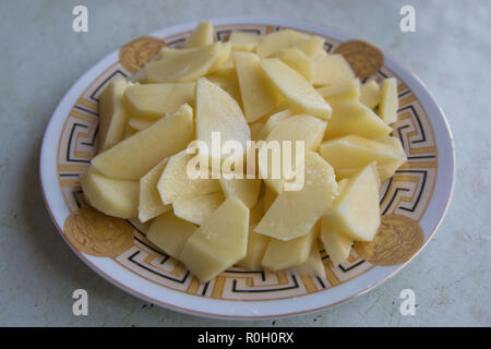 Les pommes hachées. Dans la plaque de pommes de terre hachées . Les pommes de terre crues pelées et tranchées sur une carte . Pommes hachés dans un bol . Les dés de pommes de terre - comme ingredien Banque D'Images