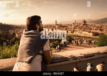 Un jeune homme admire le célèbre vue sur les toits et les basiliques de Florence depuis le Piazzale Michelangelo Banque D'Images